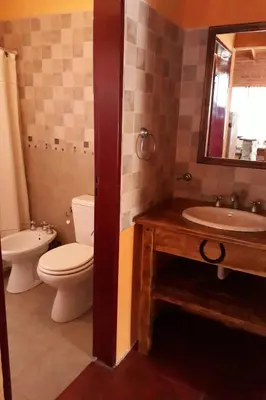 a bathroom with a toilet and a sink and a mirror at Complejo Entresierras in La Paz