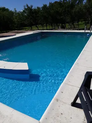a blue swimming pool with a chair in it at Complejo Entresierras in La Paz