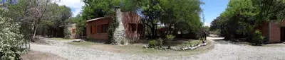 a small brick house on a gravel road with trees at Complejo Entresierras in La Paz