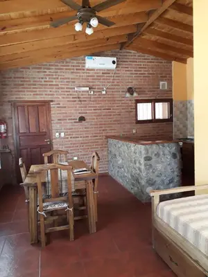 a room with a table and chairs and a brick wall at Complejo Entresierras in La Paz