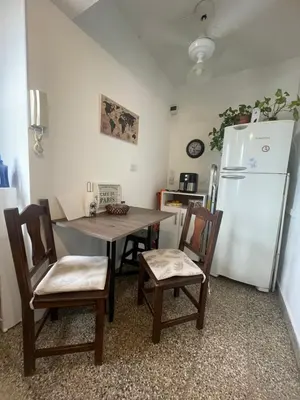 a kitchen with a table and a refrigerator at Luminoso depto de 3 amplios dormitorios y living comedor, cochera gratuita in Cordoba
