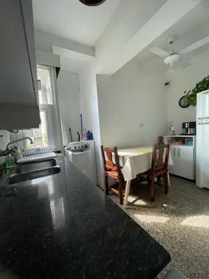 a kitchen with a table and two chairs and a counter at Luminoso depto de 3 amplios dormitorios y living comedor, cochera gratuita in Cordoba