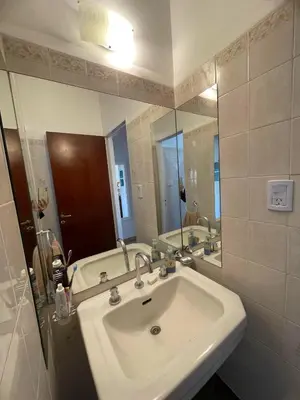 a bathroom with a sink and a large mirror at Luminoso depto de 3 amplios dormitorios y living comedor, cochera gratuita in Cordoba