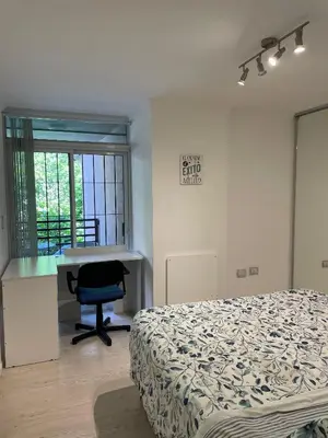 a bedroom with a bed and a desk and a chair at Departamento Nueva Cordoba in Cordoba
