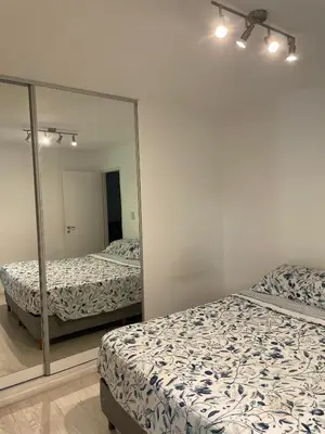 a bedroom with two beds and a mirror at Departamento Nueva Cordoba in Cordoba
