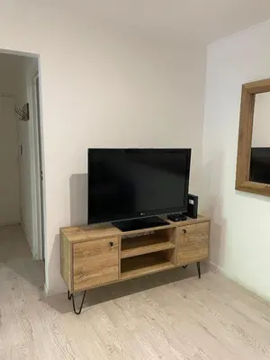 a flat screen tv sitting on top of a wooden entertainment center at Departamento Nueva Cordoba in Cordoba