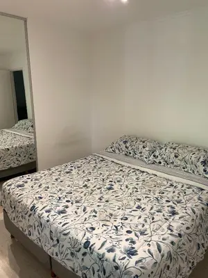 a bed in a bedroom next to a mirror at Departamento Nueva Cordoba in Cordoba