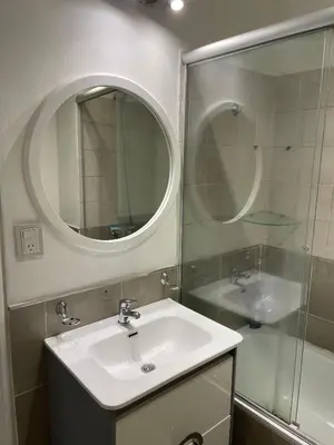 a bathroom with a sink and a mirror and a shower at Departamento Nueva Cordoba in Cordoba