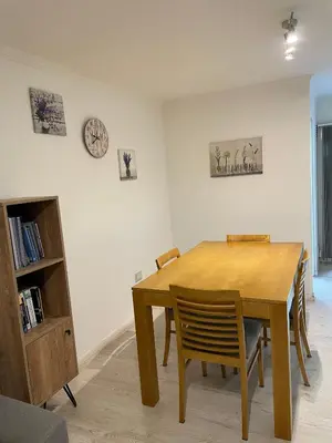 a dining room table with chairs and a clock on the wall at Departamento Nueva Cordoba in Cordoba