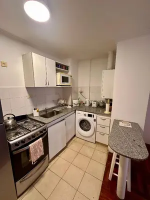 a kitchen with white cabinets and a stove top oven at Departamento Frente al Patio Olmos Shopping in Cordoba