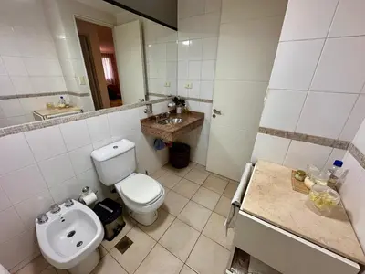 a bathroom with a white toilet and a sink at Departamento Frente al Patio Olmos Shopping in Cordoba