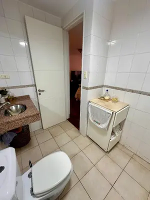 a bathroom with a white toilet and a sink at Departamento Frente al Patio Olmos Shopping in Cordoba