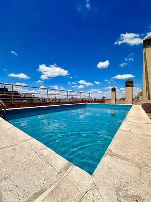 a swimming pool on the roof of a building at Departamento Frente al Patio Olmos Shopping in Cordoba
