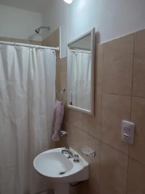 a bathroom with a sink and a mirror and a shower at Cabañas Entre Cerros in Merlo