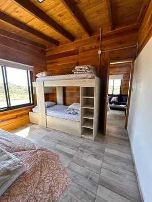 a bedroom with bunk beds in a wooden cabin at LaJu in Villa Yacanto