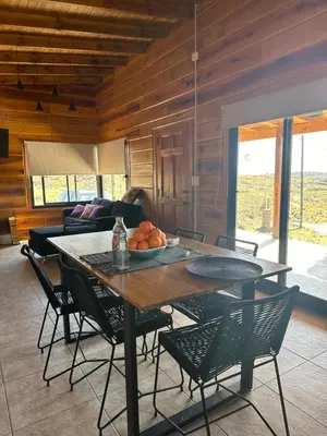 a dining room with a table and chairs and a couch at LaJu in Villa Yacanto