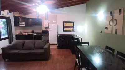 a living room with a couch and a kitchen at Moderno y acogedor Depto Céntrico V Carlos Paz 200 m terminal Sobre Av San Martin in Villa Carlos Paz