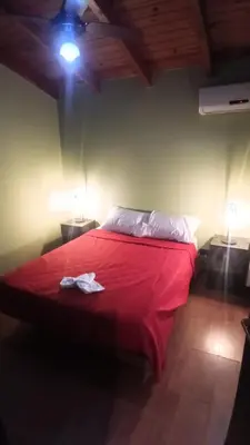 a bedroom with a red bed with a red blanket at Moderno y acogedor Depto Céntrico V Carlos Paz 200 m terminal Sobre Av San Martin in Villa Carlos Paz