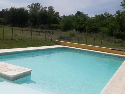 a large blue swimming pool in a yard at Lago los Molinos Punto Claro villa Silvestre depto 2 dorm y cochera in Villa Ciudad Parque