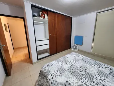 a bedroom with a bed and a wooden closet at Lago los Molinos Punto Claro villa Silvestre depto 2 dorm y cochera in Villa Ciudad Parque