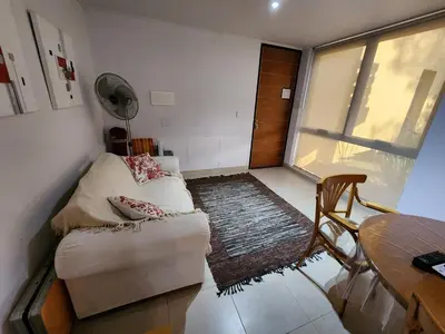 a living room with a couch and a table at Lago los Molinos Punto Claro villa Silvestre depto 2 dorm y cochera in Villa Ciudad Parque