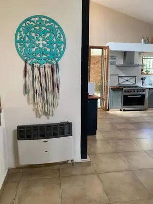 a kitchen with a wall with a fan on the wall at Hermosa casa de veraneo con pileta in Villa Carlos Paz