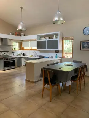 a large kitchen with a table and chairs in it at Hermosa casa de veraneo con pileta in Villa Carlos Paz