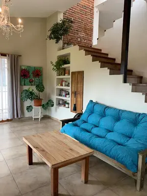 a living room with a blue couch and a table at Hermosa casa de veraneo con pileta in Villa Carlos Paz