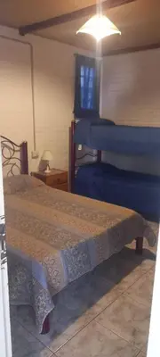a bedroom with two bunk beds and a table with a lamp at Alojamiento Nonino in Villa Cura Brochero