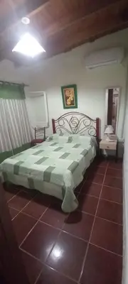 a bedroom with a bed with a green and white comforter at Alojamiento Nonino in Villa Cura Brochero