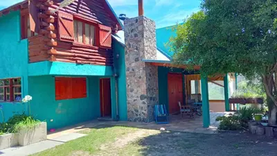 a colorful house with a red door at Chalet Tala Huasi, Costa Rio, Pileta in Villa Icho Cruz
