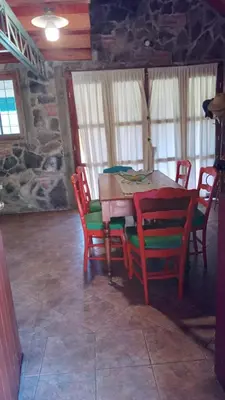 a dining room with a wooden table and chairs at Chalet Tala Huasi, Costa Rio, Pileta in Villa Icho Cruz