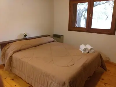a bedroom with a bed with two towels on it at La Almenara Lodge in Villa General Belgrano