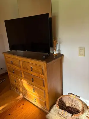 a television on top of a wooden dresser at La Almenara Lodge in Villa General Belgrano