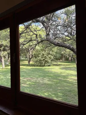 a window with a view of a field of grass at La Almenara Lodge in Villa General Belgrano