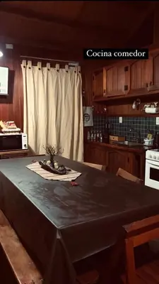 a kitchen with a table with a table cloth on it at Cabañas Lothlorien in Villa Yacanto