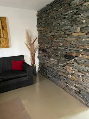 a living room with a stone wall and a couch at Mi casita en Embalse in Embalse