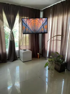 a living room with a flat screen tv in front of two windows at Mi casita en Embalse in Embalse
