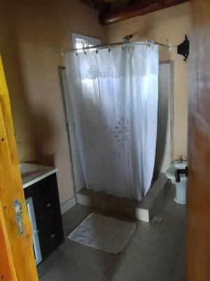 a bathroom with a shower with a white shower curtain at Tiempo libre in Villa Icho Cruz