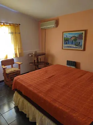 a bedroom with a bed and a chair and a window at Tiempo libre in Villa Icho Cruz