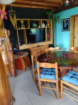 a dining room with a table and chairs and a television at Tiempo libre in Villa Icho Cruz
