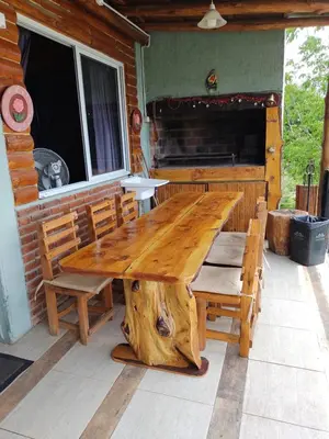 a wooden table and chairs on the porch of a cabin at Tiempo libre in Villa Icho Cruz