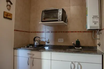 a kitchen with a sink and a toaster oven at Complejo de cabañas- Lomas del Sol in Los Reartes
