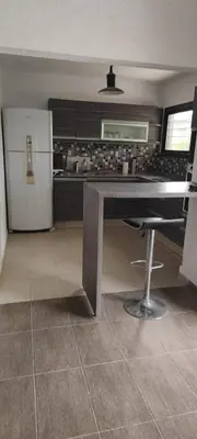 a kitchen with a table and a refrigerator at Casa villa el diquecito in La Calera