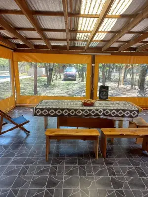 a table and benches in a room with a window at La Soñada in Villa Quillinzo