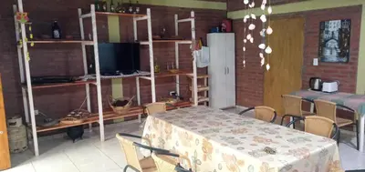 a room with a table and chairs and a refrigerator at La Soñada in Villa Quillinzo