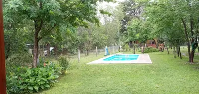 a swimming pool in a yard with trees and grass at La Soñada in Villa Quillinzo
