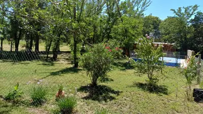a yard with a fence and trees and a pool at La Soñada in Villa Quillinzo