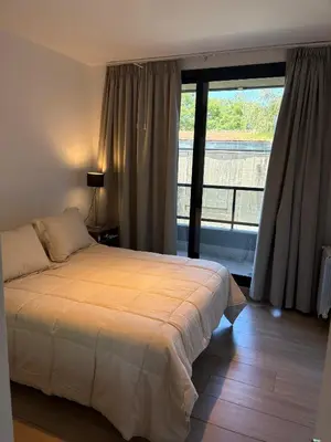 a bedroom with a bed and a large window at Complejo Las Pircas Alta Gracia in Alta Gracia
