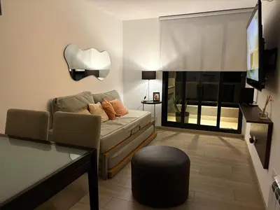 a living room with a couch and a tv at Complejo Las Pircas Alta Gracia in Alta Gracia